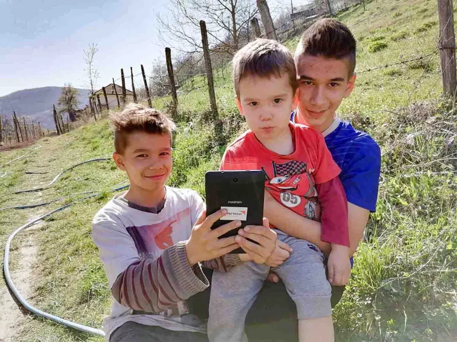Drei Jungen aus Bosnien Herzegowina mit einem Tablet