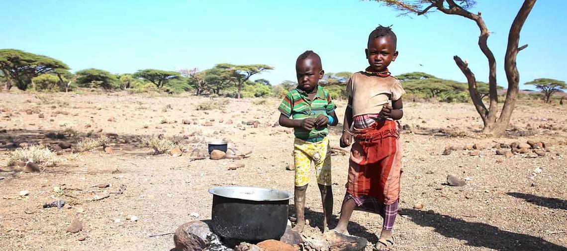 Zwei Kinder in Kenia vor einem Kochtopf