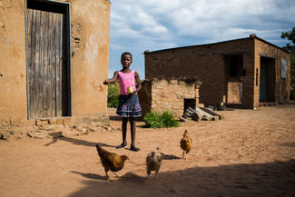 World Vision-Patenkind Praise füttert Hühner