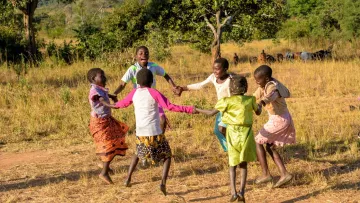 Glückliche Kinder tanzen im Kreis 