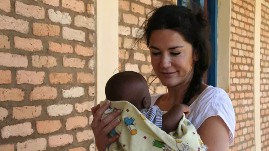 Mariella Ahrens, Schauspielerin und World Vision Botschafterin hält ein Baby in Burundi