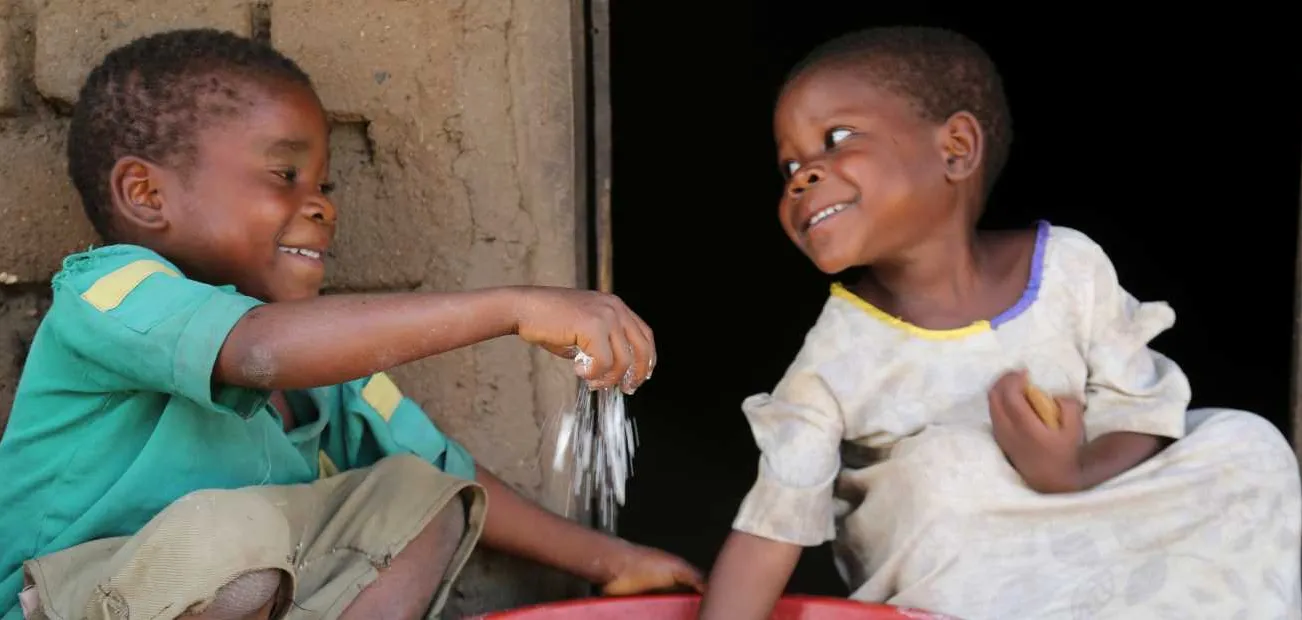 Kinder mit Maismehl in Malawi