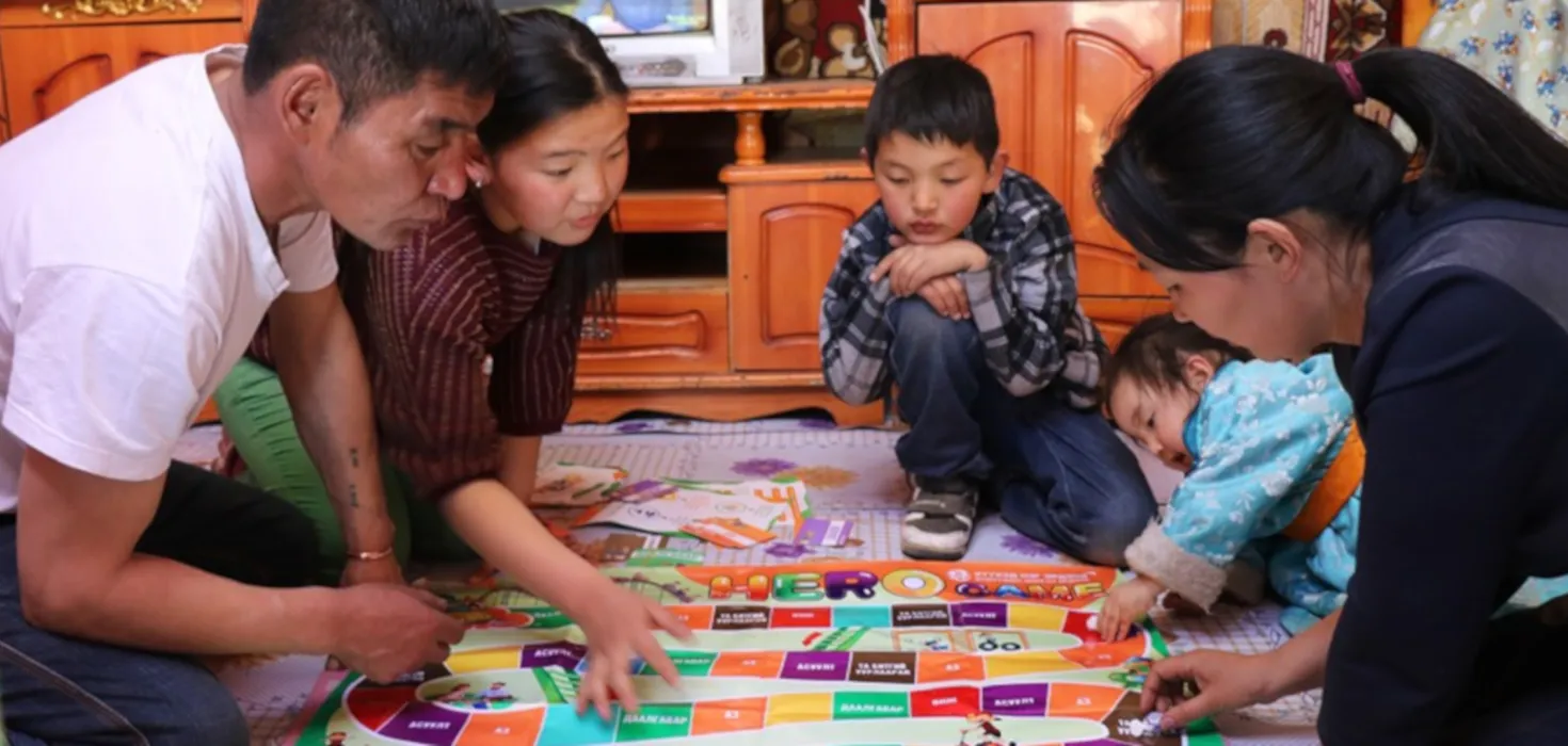 Familie in der Mongolei spielt gemeinsam das World Vision Brettspiel.