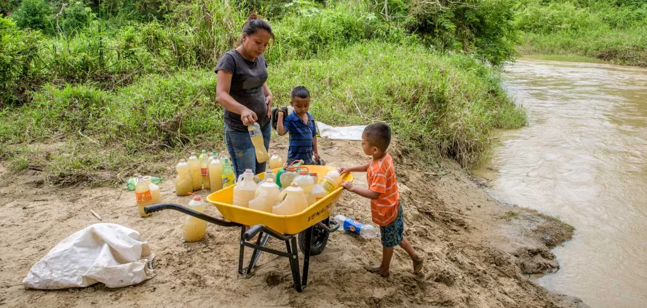 Mutter mit Kindern an einem Fluss in Honduras