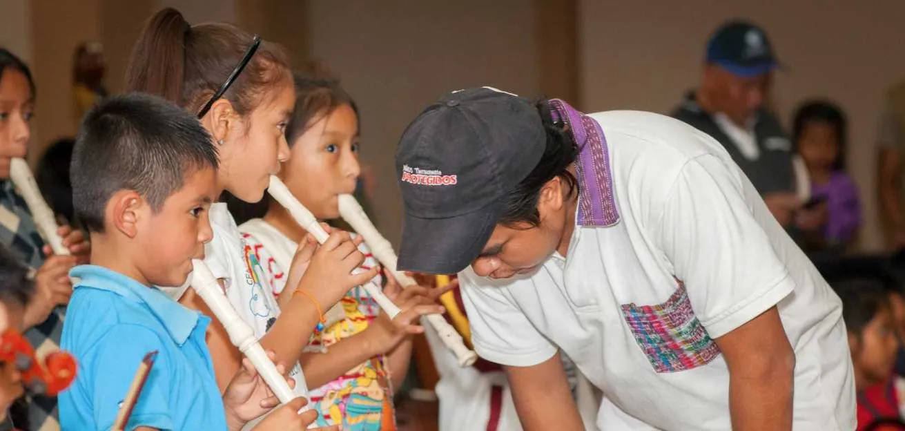 Geovanny aus Guatemala lehrt Kinder Blockflöte spielen. 