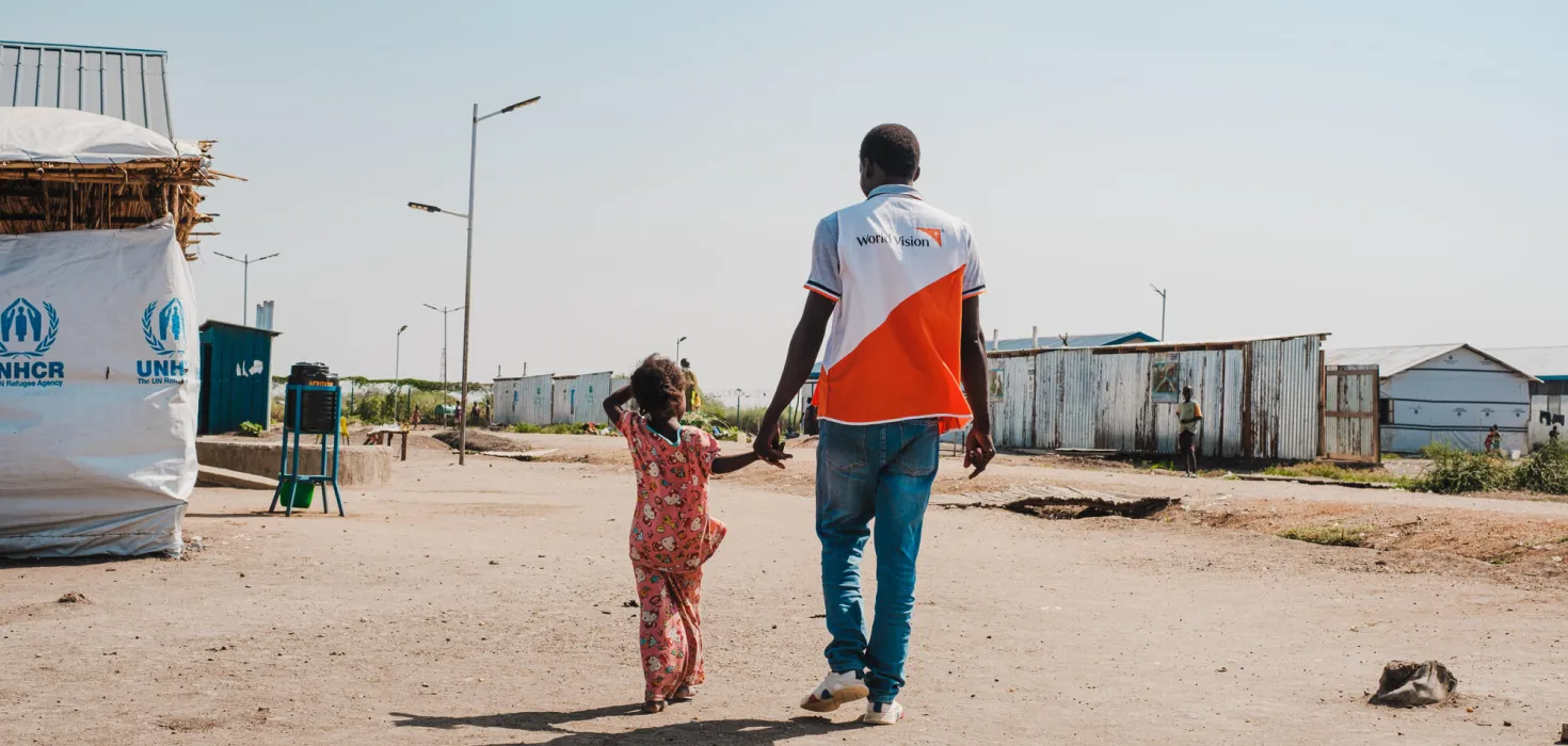 World Vision-Helfer mit geflüchtetem Kind aus Sudan