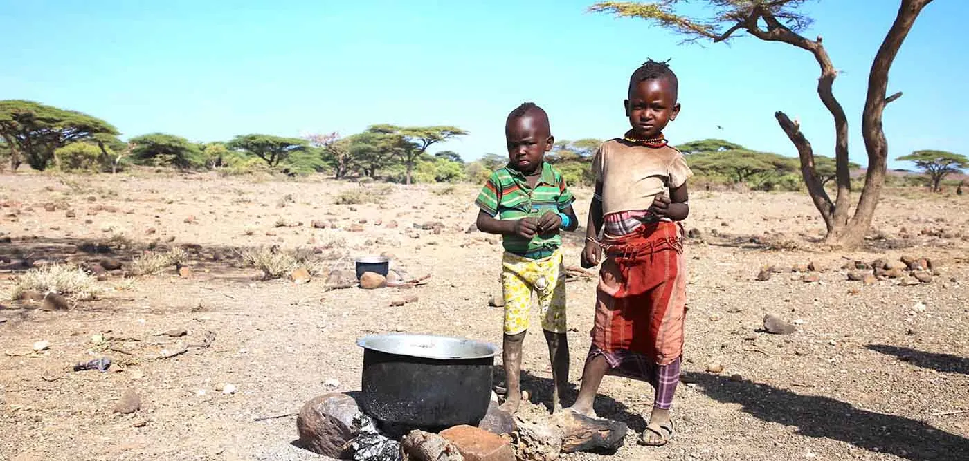 Zwei Kinder in Kenia vor einem Kochtopf