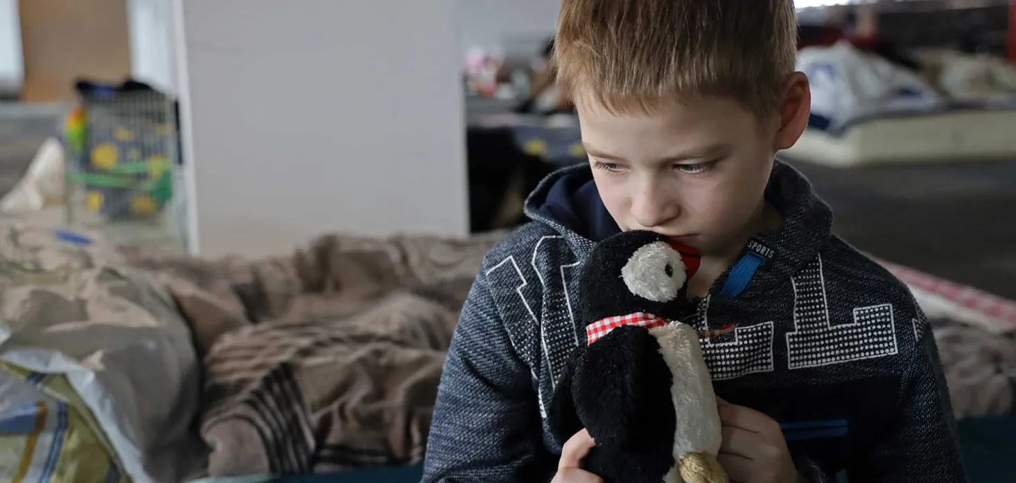 aus der Ukraine geflohener Junge mit seinem Kuscheltier