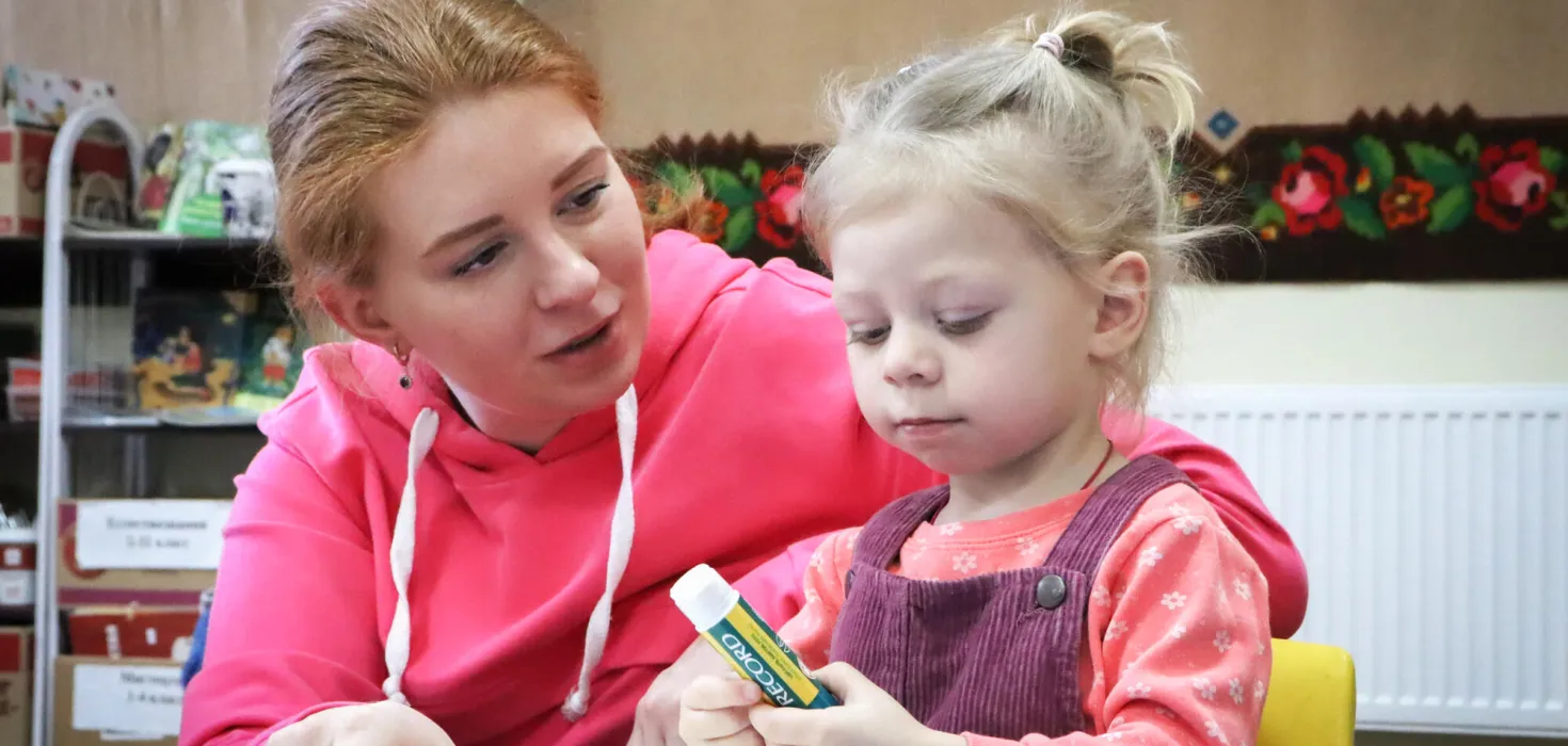 Kataryna aus der Ukraine hilft ihrer kleinen Tochter beim Basteln.