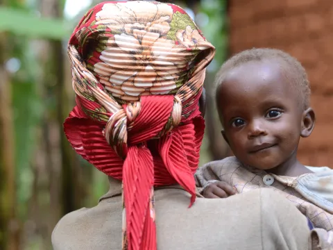 Mädchen auf dem Arm seiner Mutter in Burundi