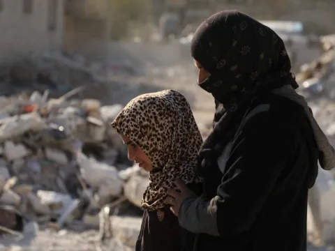 Tochter und Mutter vor Trümmern in Nordwestsyrien
