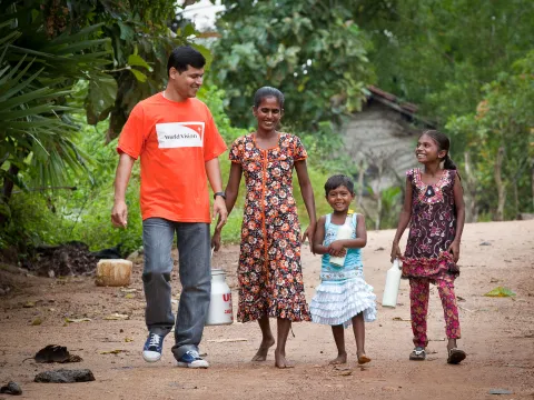 World Vision Mitarbeiterin mit einer Familie aus Sri Lanka
