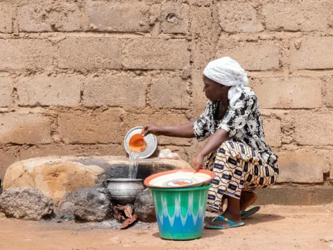 Eine afrikanische Frau schöpft Wasser