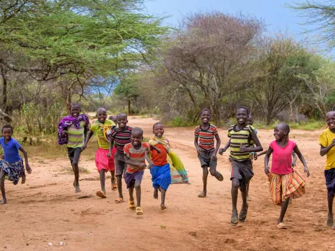 World Vision Stiftung: Kinder rennen fröhlich gemeinsam