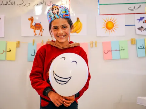 World Vision-Bildungsprojekt: Schülerin in Syrien mit lachendem Ballon