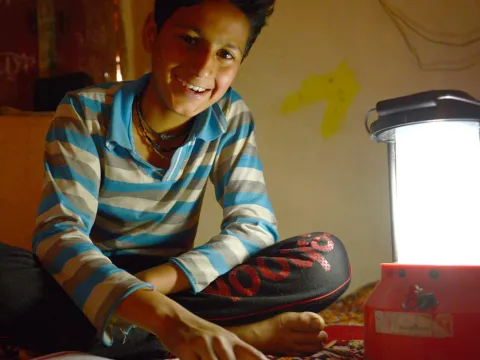 Junge mit Solarlampe aus Indien
