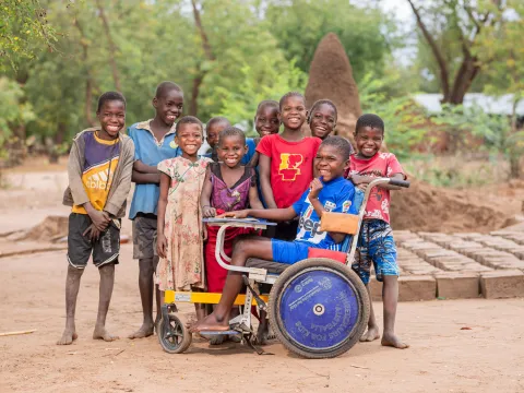 Eine Gruppe von Kindern mit einem Kind im Rollstuhl in Malawi