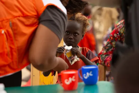 World Vision Mitarbeiter gibt Kind Aufbaunahrung