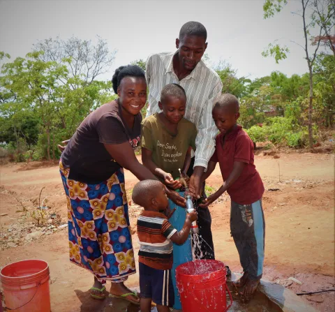 Familie freut sich über neuen Wassertank in Sambia