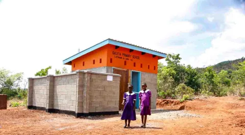 Mädchen vor einer neu gebauten Latrine