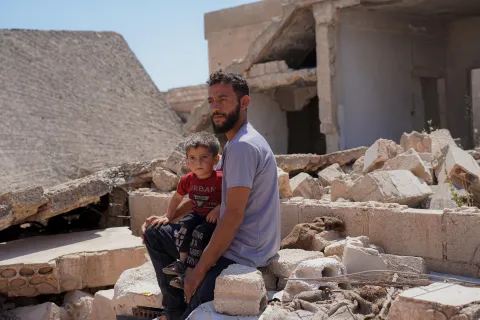 Vater mit seinem Kind in Trümmern des Krieges in Syrien