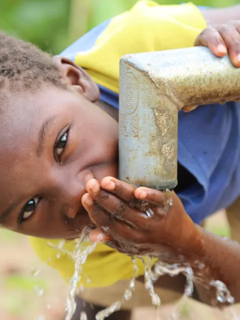 Junge trinkt sauberes Wasser in Malawi