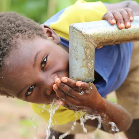 Junge trinkt sauberes Wasser in Malawi