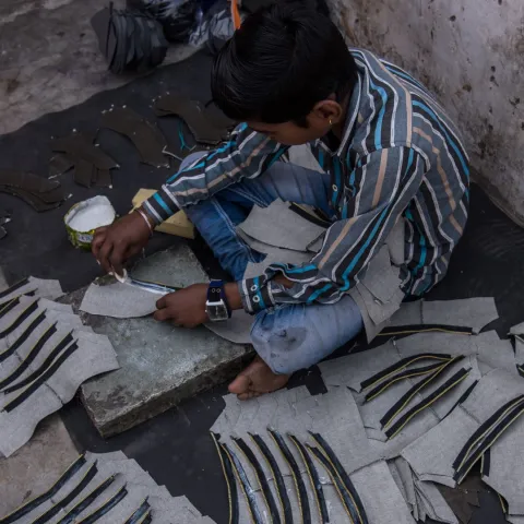Kinderarbeiter Karan aus Bangladesch klebt Schuhteile zusammen