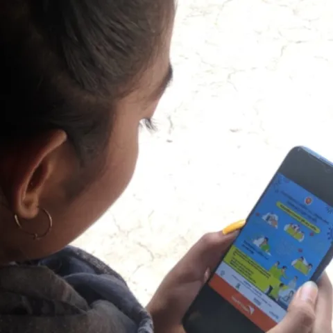 Farzana aus Bangladesch steht via Handy mit anderen Kindern in Kontakt