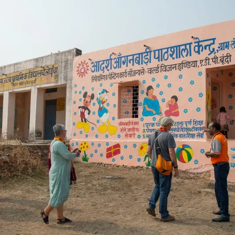 Paten vor einem World Vision Gebäude in Indien