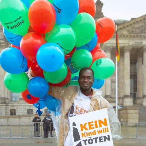 Innocent Owonya spricht bei der World Vision-Aktion am Bundestag im Namen vieler ehemaliger Kindersoldaten die auf eine Chance zu einem Leben ohne Gewalt hoffen.
