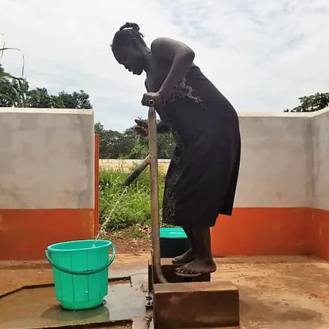 Ein Frau in der zentralafrikanischen Republik pumpt Wasser aus einem neuen Brunnen.