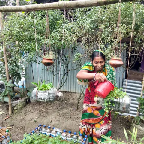 Rani aus Bangladesch hat Spaß an ihrem hängenden Garten - mit gesammelten Altplastik-Flaschen als Gefäßen, in dem das angepflanzte Gemüse besser vor einer Überschwemmung geschützt ist als auf dem Boden.