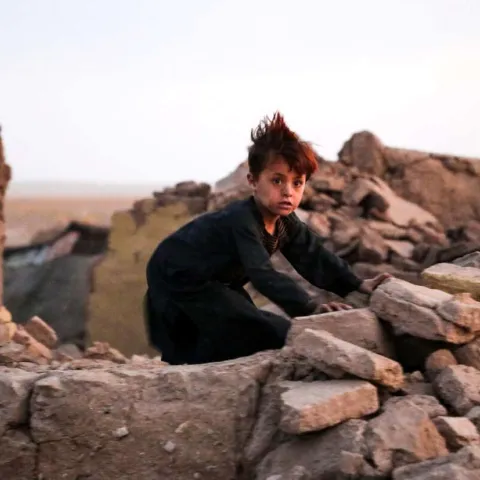 Junge in den Trümmern eines Hauses nach dem Erdbeben in Afghanistan