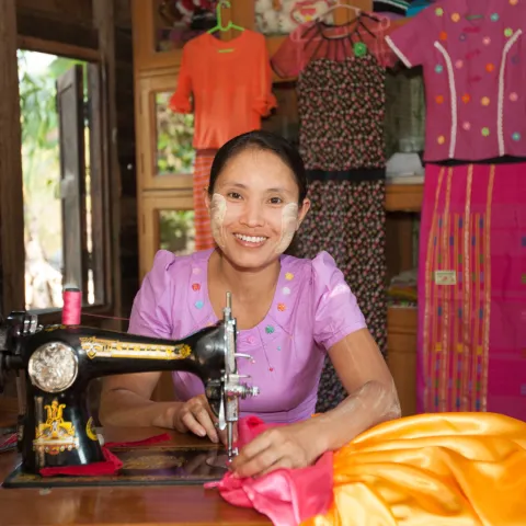 Frau aus Myanmar arbeitet an einer Nähmaschine.