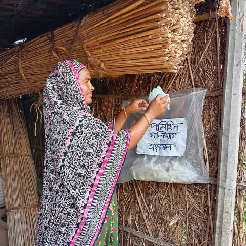 Für Umweltschutz sensibilisiert: Eine Bewohnerin eines von World Vision unterstützten Dorfes in Bangladesch sammelt Plastikabfälle fürs Recycling.
