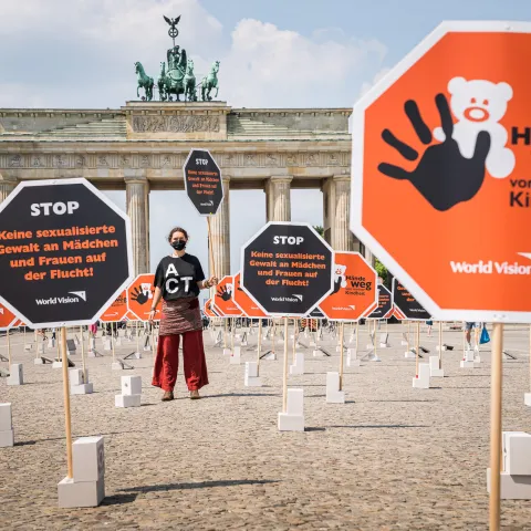 Aktionsteilnehmerin mit T-Shirt "Act" am Brandenburger Tor