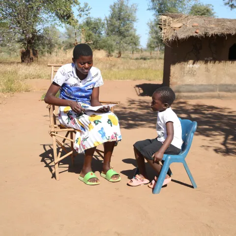 Ein Kind aus Malawi wird von einer Jugendichen zu seinen Erfahrungen mit Schulmahlzeiten befragt