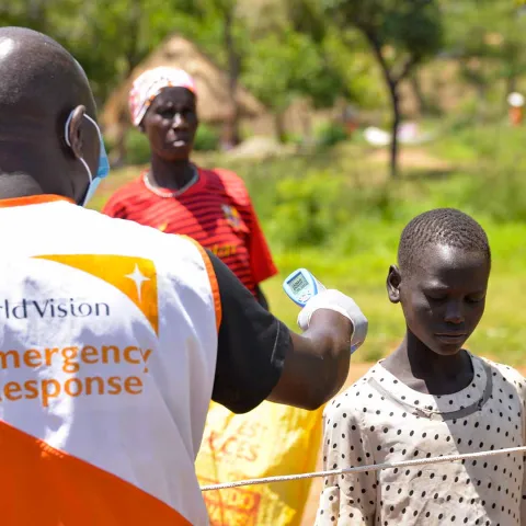 World Vision Mitarbeiter misst die Körpertemperatur