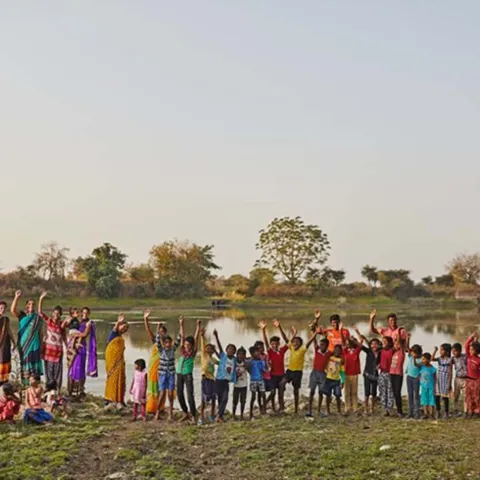 Kinder in Indien winken in die Kamera