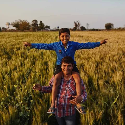 Vater mit Kind in seinem Feld in Indien