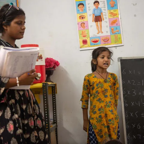 Mädchen mit Lehrerin vor der Klasse in Indien