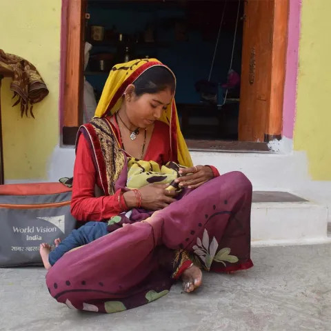 Mutter stillt ihr Kind  in Pratapgarh