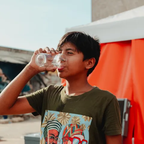 Junge trinkt sicheres Wasser nach dem Erdbeben in Venezuela