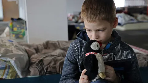 aus der Ukraine geflohener Junge mit seinem Kuscheltier