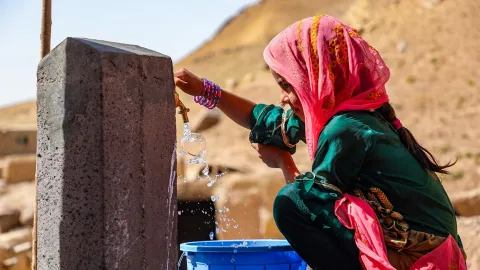 Mädchen in Afghanistan an einem Brunnen