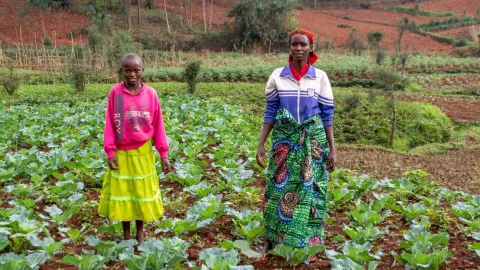 Mädchen mit ihrer Mutter auf dem Feld in Burundi
