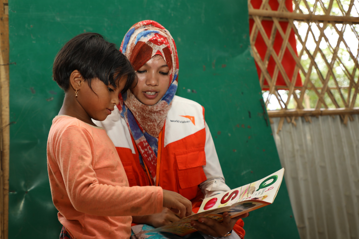 Leseübung in einem World Vision-KInderzentrum in Cox' Bazar (Bangladesch) mit einem  geflüchteten Mädchen