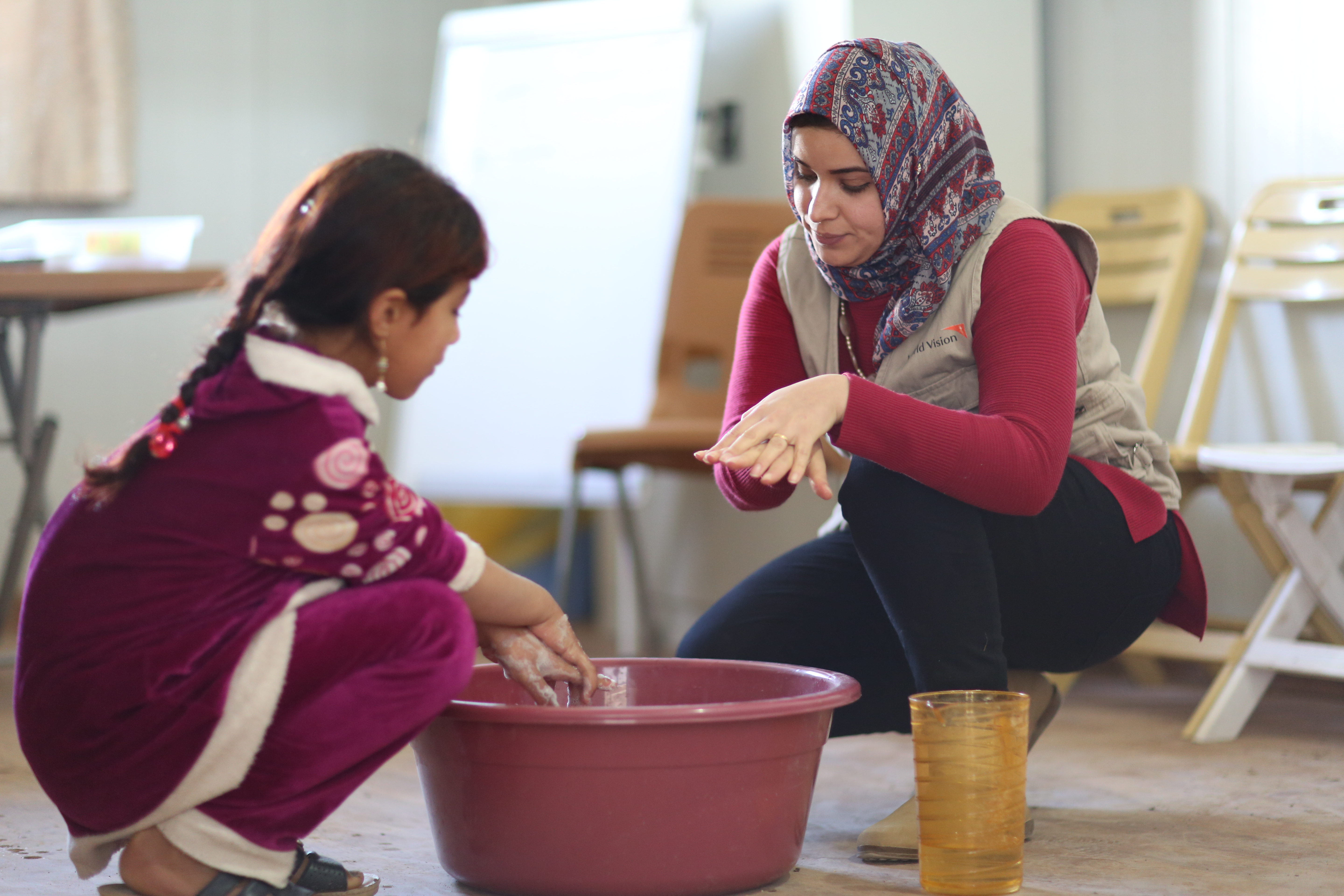 World Vison-Mitarbeiterin zeigt einem Mädchen in Kirkuk richtiges Händewaschen
