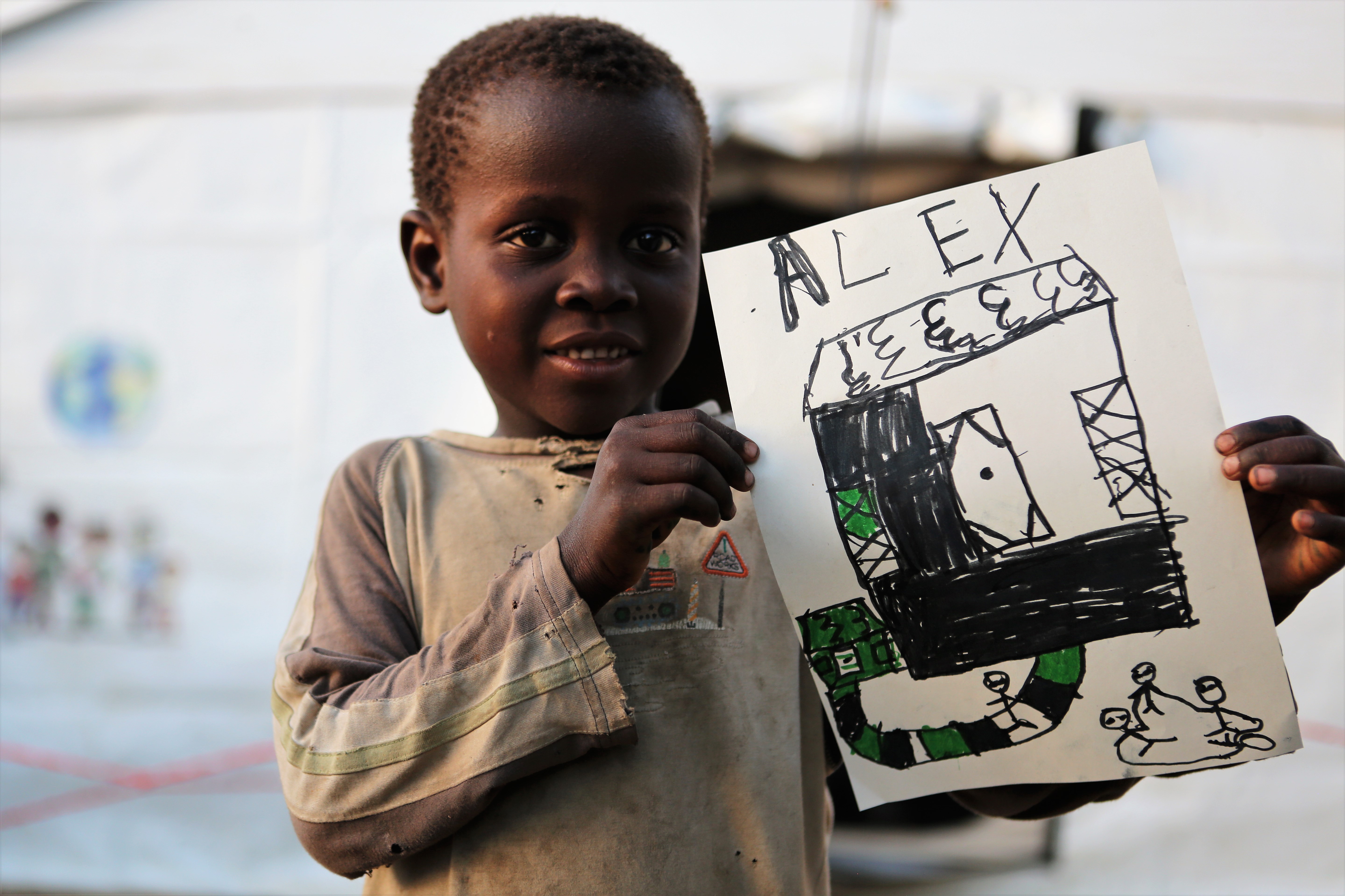 Ein Junge aus Mosambik zeigt ein gemaltes Bild von seiner Situation nach Zyklon Idai
